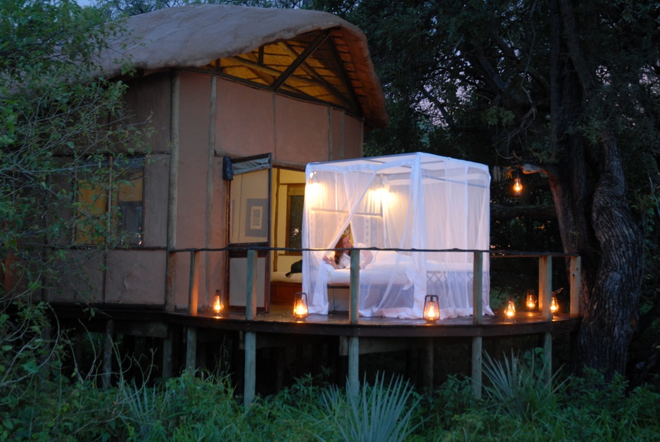 Sanctuary Baines Camp tent at night with bed under the open sky