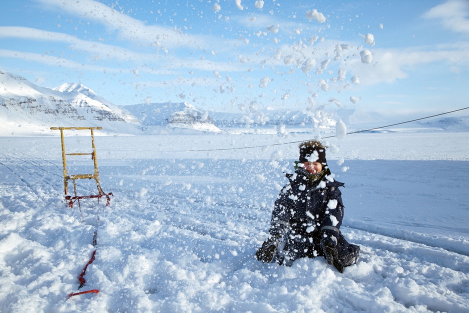 Kid enjoying the sledging on the ice of the fjord