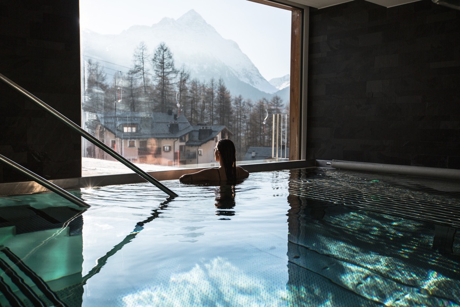 Nira Alpina whirpool with a woman inside enjoying the Alpine view