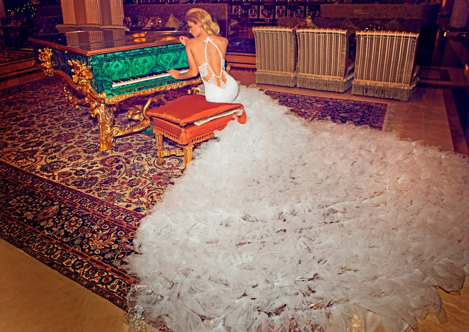 Woman in an elegant white wedding dress playing on a green piano