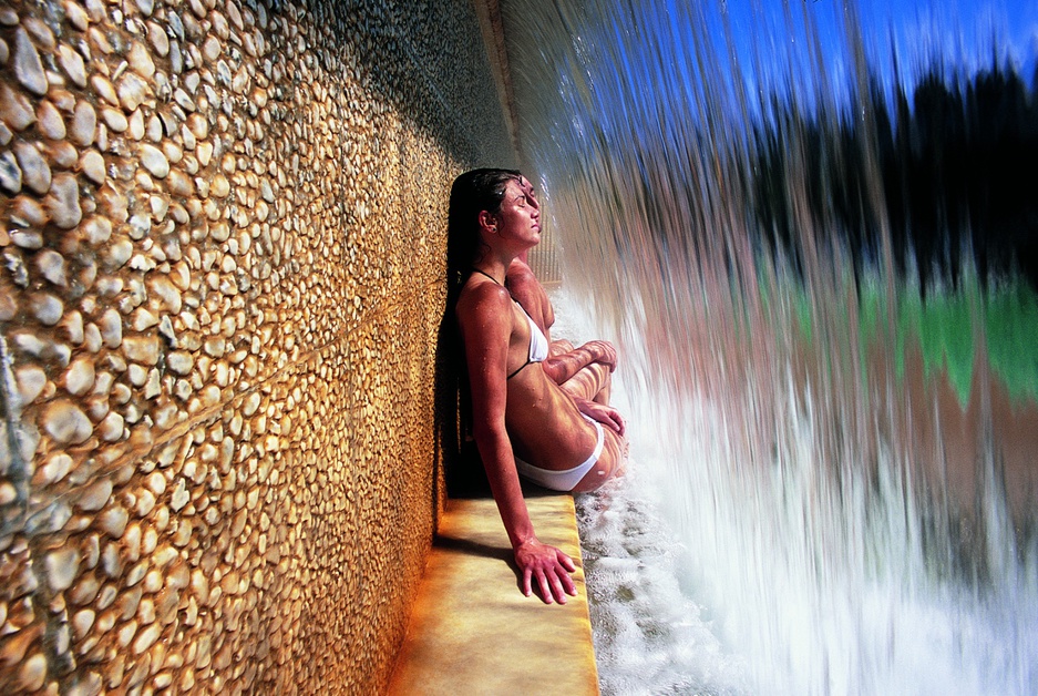 You couple sitting under a waterfall at Fonteverde hotel