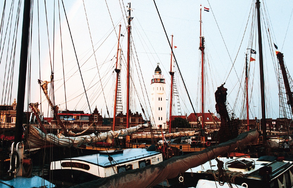 Boats docked and the Harlingen Lighthouse in the background