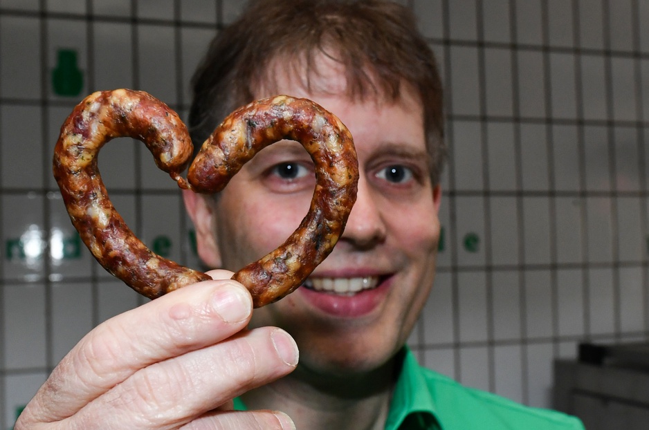 Claus Böbel, the owner of Bratwurst Hotel with a sausage in his hand