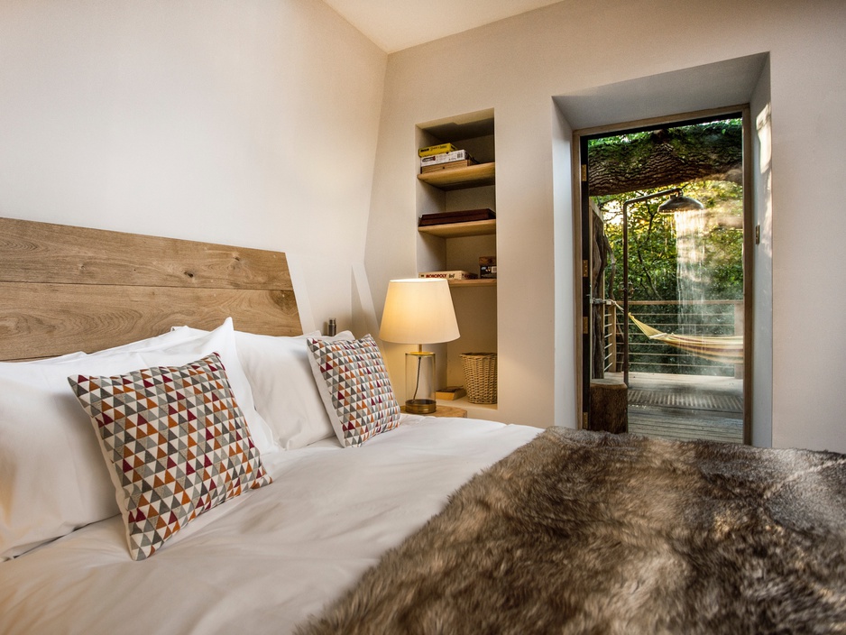 The Woodman's Treehouse bedroom with view on the outdoor shower