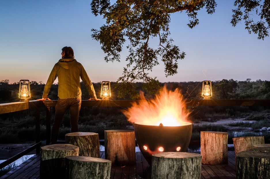 Singita Boulders Lodge fireplace on the terrace at night