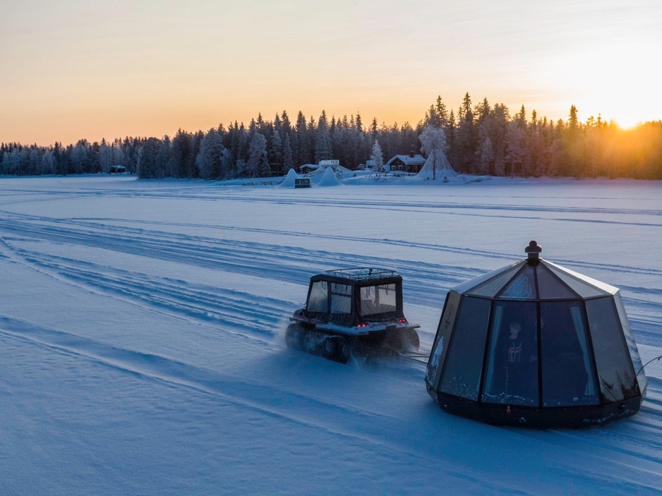 AuroraHut pulled at frozen lake Ranua with an ATV during winter