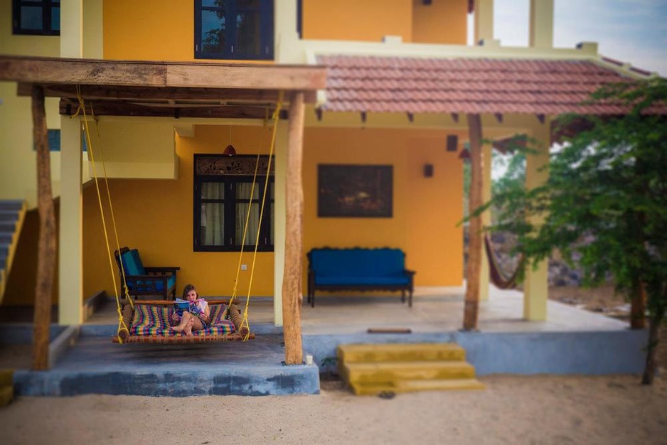 Elephant Road Resort terrace with a hanging bed and a girl relaxing on it