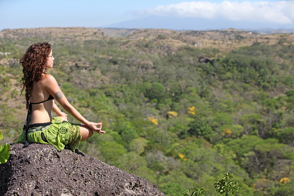 Girl meditating on the rock