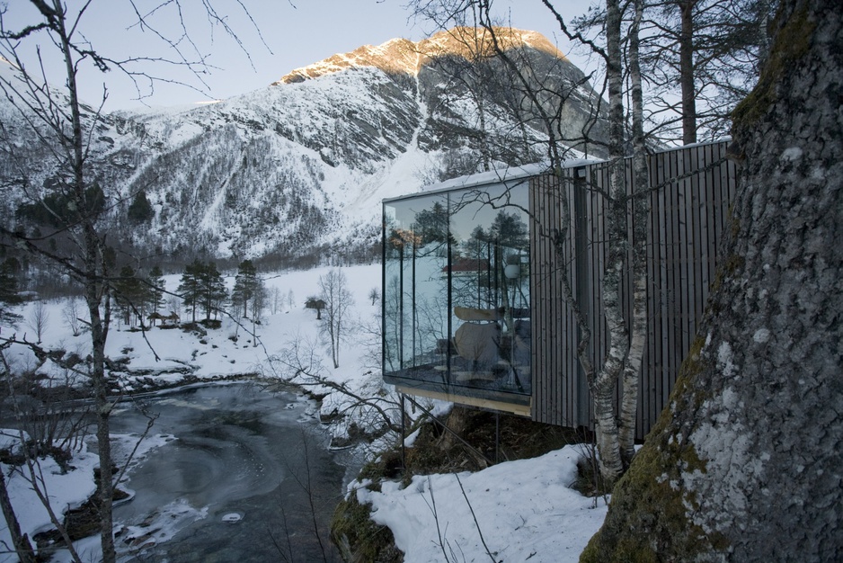 Snowy Norwegian landscape with the glass cabins of Juvet Landscape Hotel