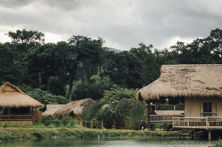 Lisu Lodge Bamboo House Next to a Pond